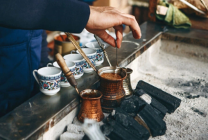 A traditional Turkish coffee set with a cezve, small cups, and lokum